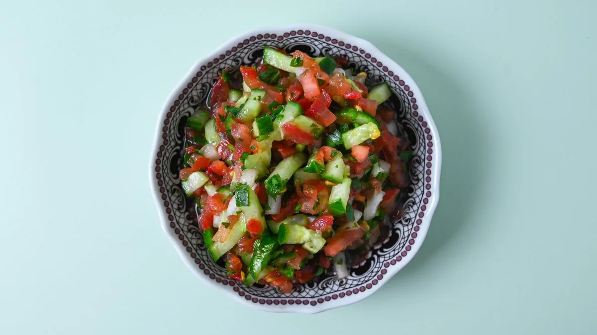 Kleopatra-Salat: fein gewürfelte Gurke, Tomate, Zwiebel und Petersilie mit Zitronen-Granatapfel-Dressing.